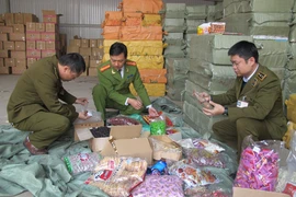 Lực lượng Công an và Quản lý thị trường phối hợp bắt giữ hàng lậu. (Ảnh: Đức Duy/Vietnam+)