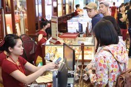 Khách hàng đang giao dịch vàng miếng. (Ảnh: Đức Duy/Vietnam+)