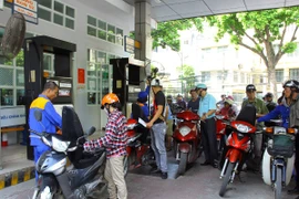 Nhân viên Petrolimex đang bán xăng cho khách hàng. (Ảnh: Đức Duy/Vietnam+)