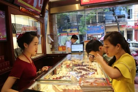 Khách hàng đang giao dịch vàng miếng. (Ảnh: Đức Duy/Vietnam+)