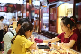 Khách hàng đang giao dịch vàng miếng. (Ảnh: Đức Duy/Vietnam+)