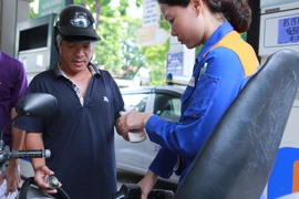 Nhân viên Petrolimex đang bán xăng cho khách hàng. (Ảnh: Đức Duy/Vietnam+)