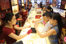 Khách hàng đang giao dịch vàng miếng. (Ảnh: Đức Duy/Vietnam+)