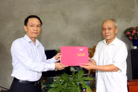 Đồng chí Nguyễn Đức Lợi, Tổng Giám đốc Thông tấn xã Việt Nam tặng quà gia đình liệt sỹ Phạm Thị Đệ. (Ảnh: TTXVN)