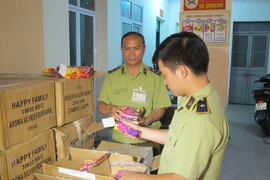 Cán bộ Đội Quản lý thị trường số 5 đang kiểm đếm pháo hoa điện nhập lậu vừa thu giữ trên địa bàn. (Ảnh: Đức Duy/Vietnam+)