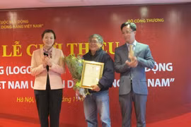 Đại diện Ban chỉ đạo trao chứng nhận cho họa sỹ Nguyễn Văn Thân, người sáng tác logo chính thức cuộc vận động "Người Việt Nam ưu tiên dùng hàng Việt Nam. (Ảnh: Đức Duy/Vietnam+)