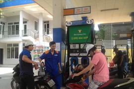 Nhân viên Petrolimex đang bán xăng cho khách hàng. (Ảnh: Đức Duy/Vietnam+)