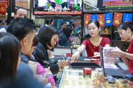 Khách hàng đang giao dịch vàng miếng tại Công ty Bảo Tín Minh Châu Hà Nội. (Ảnh: Đức Duy/Vietnam+)