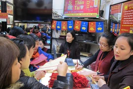 Khách hàng đang giao dịch vàng miếng. (Ảnh: Đức Duy/Vietnam+)