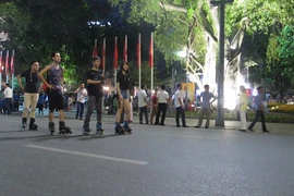 Các bạn trẻ rất hào hứng vui chơi trên tuyến phố đi bộ mới khai trương. (Ảnh: Tiến Đạt/Vietnam+)