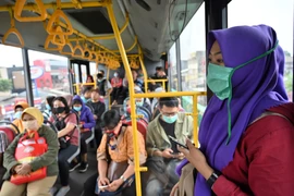 Hành khách đeo khẩu trang phòng lây nhiễm COVID-19 tại Jakarta, Indonesia, ngày 18/3/2020. (Ảnh: AFP/TTXVN)