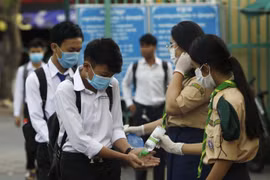 Các học sinh tiến hành sát khuẩn tay nhằm ngăn dịch COVID-19 lây lan, trước khi vào lớp ở Phnom Penh, Campuchia, ngày 2/11/2020. (Ảnh: AFP/TTXVN)