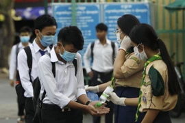 Các học sinh tiến hành sát khuẩn tay nhằm ngăn dịch COVID-19 lây lan, trước khi vào lớp ở Phnom Penh, Campuchia, ngày 2/11/2020. (Ảnh: AFP/TTXVN)