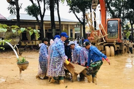 Lực lượng đoàn viên thanh niên giúp các trường học ở xã Hướng Việt khắc phục hậu quả lũ lụt. (Ảnh: Hồ Cầu/TXVN)