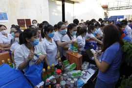 Công nhân lao động mua sắm tại phiên chợ 0 đồng. (Ảnh: Thanh Vũ/TTXVN)