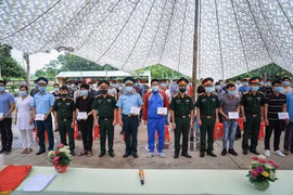 Đại diện Trung tâm Kiểm soát Bệnh tật, Bộ Chỉ huy Quân sự tỉnh cùng các đơn vị chức năng tổ chức trao Giấy chứng nhận hoàn thành thời gian cách ly cho các công dân. (Ảnh: Trọng Đạt/TTXVN)