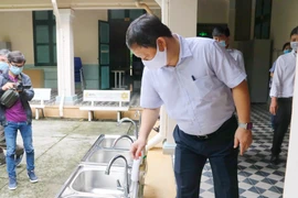 Phó Chủ tịch UBND thành phố Hồ Chí Minh Dương Anh Đức kiểm tra khu vực rửa tay, sát khuẩn tại trường THPT chuyên Trần Đại Nghĩa, quận 1. (Ảnh: Thu Hương/TTXVN)
