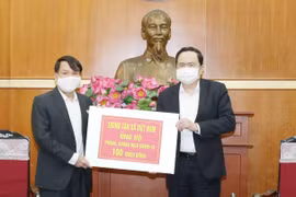 Đồng chí Trần Thanh Mẫn, Bí thư Trung ương Đảng, Chủ tịch Ủy ban Trung ương Mặt trận Tổ quốc Việt Nam tiếp nhận ủng hộ từ Thông tấn xã Việt Nam. (Ảnh: Phương Hoa/TTXVN)