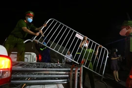 Các lực lượng chức năng gỡ bỏ hàng rào cách ly tại thôn Đông Cứu - ổ dịch COVID-19 cuối cùng tại Việt Nam tính đến thời điểm này đã được tẩy sạch virus SARS-CoV-2. (Ảnh: Minh Quyết - TTXVN)