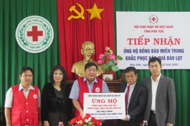 Đại diện Bộ Ngoại giao Việt Nam trao tiền và hiện vật của cộng đồng người Việt tại Mỹ ủng hộ tỉnh Phú Yên. (Ảnh: Xuân Triệu/TTXVN)