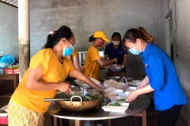 Đoàn Thanh niên và Hội Phụ nữ xã Vĩnh Hòa chuẩn bị những suất ăn, hỗ trợ lực lượng làm nhiệm vụ phong tỏa thôn Đơn Duệ. (Ảnh: TTXVN)