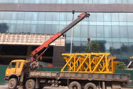 Phương tiện được tập kết tại chân tòa nhà 8B Lê Trực chuẩn bị cho việc tháo dỡ phần vi phạm giai đoạn 2 của tòa nhà. (Ảnh Mạnh Khánh/TTXVN)