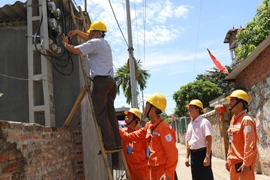 Đại diện Tổng cục Tiêu chuẩn Đo lường Chất lượng kiểm tra chì niêm phong côngtơ khách hàng sử dụng điện tại Công ty Điện lực Mê Linh, Hà Nội. (Ảnh: Ngọc Hà/TTXVN)