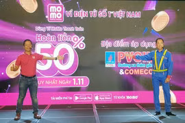 Đại diện PVOIL và Ví MoMo phát động thí điểm ứng dụng thanh toán bằng ví điện tử tại cửa hàng xăng dầu. (Ảnh: Mỹ Phương/TTXVN)