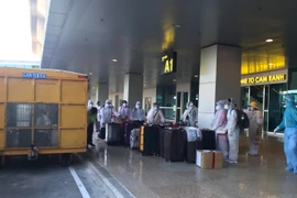 Công dân Việt Nam từ nước ngoài trở về chuẩn bị rời sân bay Cam Ranh đến khu cách ly tập trung. (Ảnh: Phan Sáu/TTXVN)