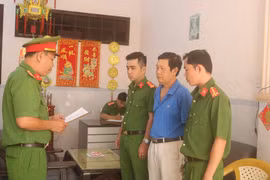 Cơ quan Cảnh sát điều tra Công an tỉnh Trà Vinh tống đạt quyết định khởi tố bị can, bắt tạm giam Trầm Ngọc Long. (Ảnh: Thanh Hòa/TTXVN)