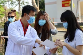 Bác sỹ Bệnh viện dã chiến Củ Chi hướng dẫn và căn dặn bệnh nhân tự cách ly tại nhà sau xuất viện. (Ảnh: Đinh Hằng/TTXVN)