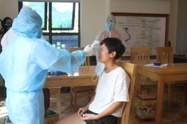 Cán bộ y tế đo thân nhiệt, lấy mẫu xét nghiệm cho các trường hợp người nước ngoài nhập cảnh cách ly tập trung. (Ảnh: Hải Yến/TTXVN)