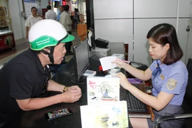 Nhân viên tại Ga Sài Gòn hướng dẫn hành khách thủ tục mua vé tàu. (Ảnh: Tiến Lực/TTXVN)