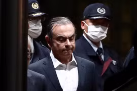 Cảnh sát áp giải cựu Chủ tịch Nissan Carlos Ghosn (giữa) rời khỏi khu giam giữ ở Tokyo, sau khi ông được trả tự do có bảo lãnh, ngày 25/4/2019. (Ảnh: AFP/TTXVN)