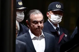 Cảnh sát áp giải cựu Chủ tịch Nissan Carlos Ghosn (giữa) rời khỏi khu giam giữ ở Tokyo, sau khi ông được trả tự do có bảo lãnh, ngày 25/4/2019. (Ảnh: AFP/TTXVN)