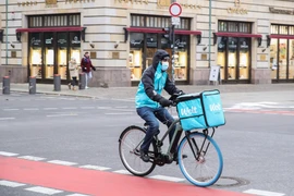 Nhân viên giao hàng đeo khẩu trang phòng dịch COVID-19 đi trên đường phố vắng vẻ tại Berlin, Đức ngày 26/11/2020. (Ảnh: THX/TTXVN)