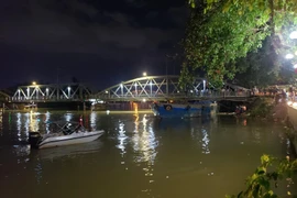 Chiếc sà lan 500 tấn mắc kẹt dưới gầm cầu Rạch Cát. (Ảnh: Lê Xuân/TTXVN)