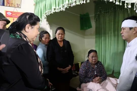 Phó Chủ tịch Thường trực Quốc hội Tòng Thị Phóng chia sẻ mất mát với gia đình đồng chí Nguyễn Văn Bình, nguyên Chủ tịch UBND huyện Phong Điền đã hy sinh khi đi làm nhiệm vụ cứu hộ, cứu nạn. (Ảnh: Đỗ Trưởng/TTXVN)