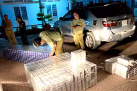 Lực lượng chức năng kiểm tra và tạm giữ số thuốc lá điếu nhập lậu. (Ảnh: Lê Thúy Hằng/TTXVN)