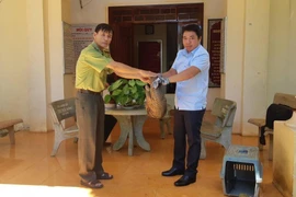 Đại diện Hạt kiểm lâm Bù Đăng bàn giao cá thể tê tê cho vườn Quốc Gia Bù Gia Mập. (Ảnh: Đậu Tất Thành/TTXVN)