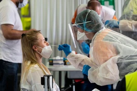 Nhân viên y tế lấy mẫu xét nghiệm COVID-19 cho người dân tại Saint Louis, Pháp. (Ảnh: AFP/TTXVN)