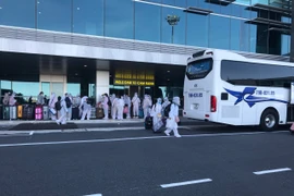 Công dân Việt Nam từ Đài Loan trở về nước lên xe đến các khu cách ly tập trung. (Ảnh: Phan Sáu/TTXVN)