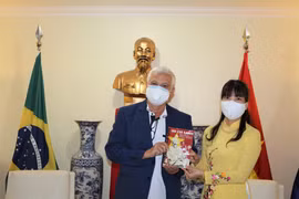 Đại sứ Phạm Thị Kim Hoa tặng quà ông Romênio Pereira - Thư ký ban Quan hệ quốc tế Đảng Công nhân Braxin. (Ảnh: TTXVN/phát)