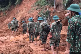 Lực lượng cứu hộ, cứu nạn hành quân tới hiện trường vụ sạt lở trong điều kiện vô cùng khó khăn do đường giao thông có nhiều điểm bị sạt lở nghiêm trọng. (Ảnh: Thanh Thủy/TTXVN)