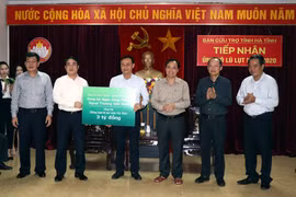 Doanh nghiệp khối cơ quan Trung ương Ngân hàng TMCP Ngoại thương Việt Nam trao tiền ủng hộ cho Hà Tĩnh. (Ảnh: Công Tường/TTXVN)