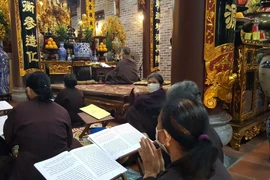 Phật tử hành lễ nhưng vẫn thực hiện nghiêm đeo khẩu trang phòng chống dịch. (Ảnh: Đinh Thuận/TTXVN)