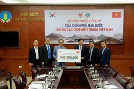 Ông Park Noh-Wan, Đại sứ Hàn Quốc tại Việt Nam trao tượng trưng gói hỗ trợ 300.000 USD cho Ủy viên Ban Chỉ đạo Trung ương về Phòng, chống thiên tai Nguyễn Hoàng Hiệp. (Ảnh: Vũ Sinh/TTXVN)