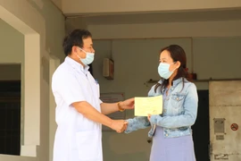 Tiến sỹ-bác sỹ Châu Đương, Giám đốc Bệnh viện Lao và bệnh phổi tỉnh Đắk Lắk trao giấy xuất viện cho bệnh nhân 601. (Ảnh: Tuấn Anh/TTXVN)