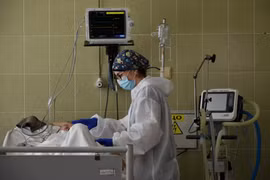 Nhân viên y tế điều trị cho bệnh nhân mắc COVID-19 tại một bệnh viện ở Lviv, Ukraine. (Ảnh: AFP/TTXVN)