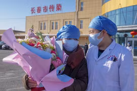 Bệnh nhân nhiễm virus corona (trái) được xuất viện sau khi điều trị tại bệnh viện ở Trường Xuân, tỉnh Cát Lâm, Trung Quốc, ngày 30/1/2020. (Ảnh: THX/TTXVN)